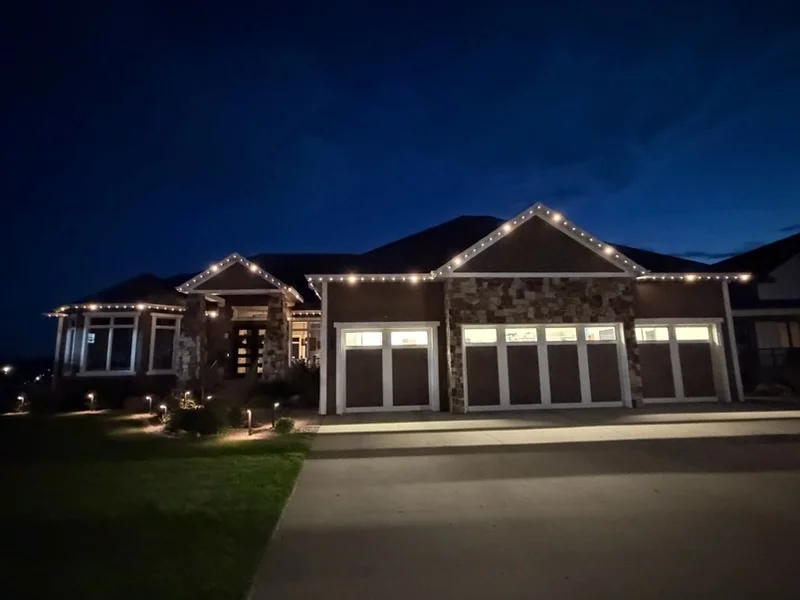 Residential home with LED roofline and landscape lighting at dusk