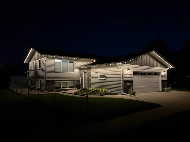 Two-story home with LED soffit, fascia, and landscape lighting at night