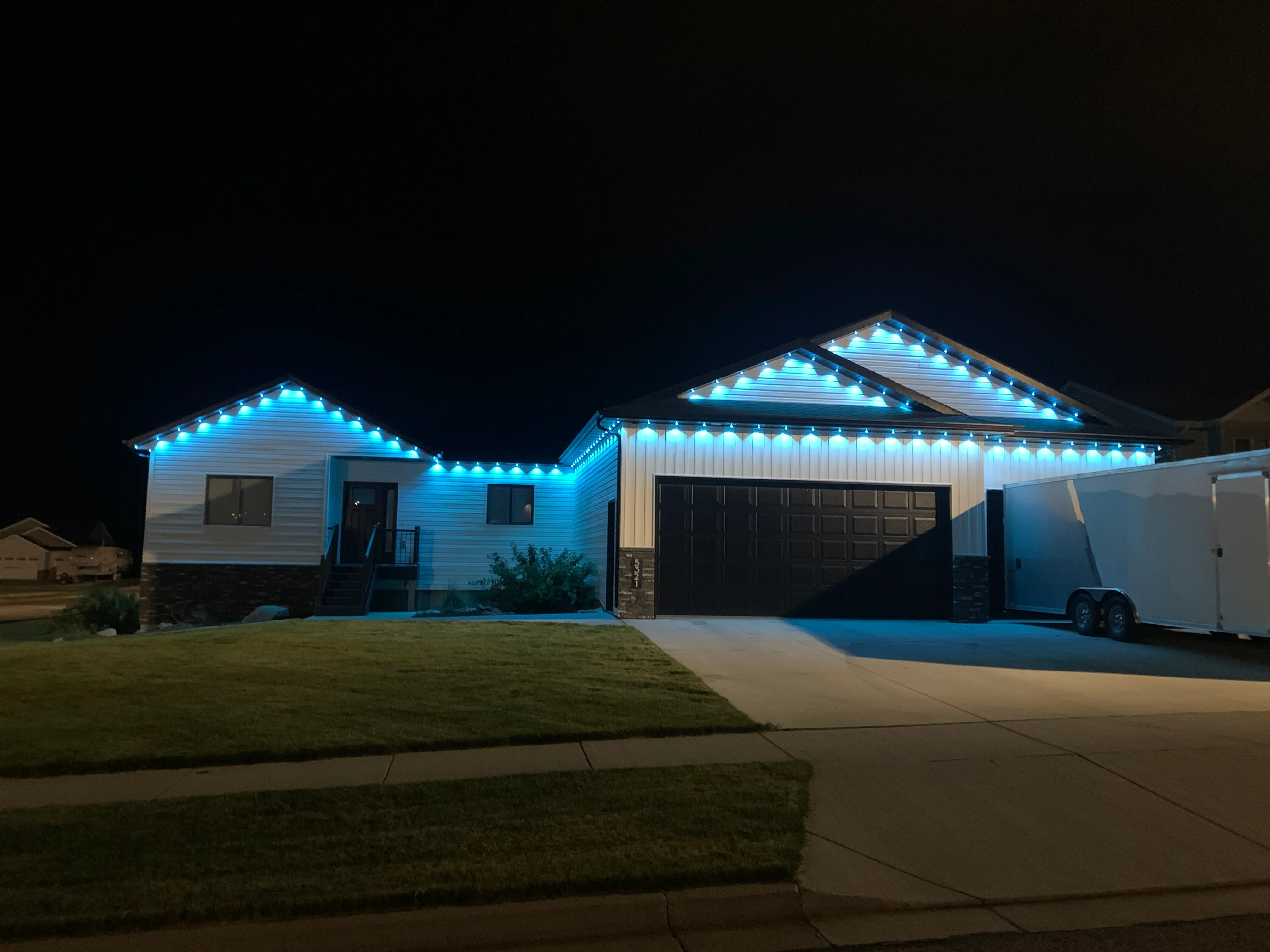 Blue LED eave and roofline lighting on residential home exterior at night