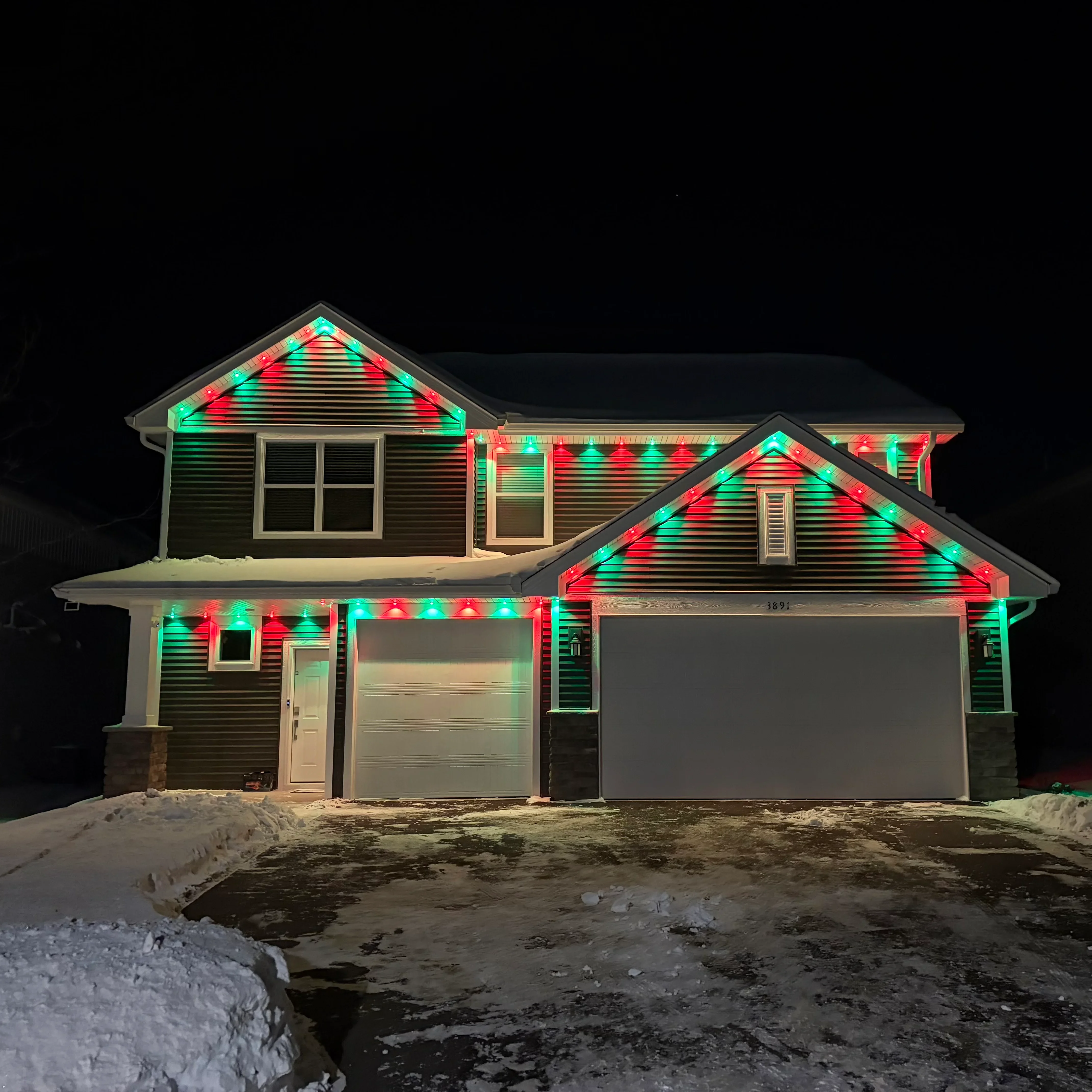 Red and green LED roofline lighting installed on residential home gables and fascia