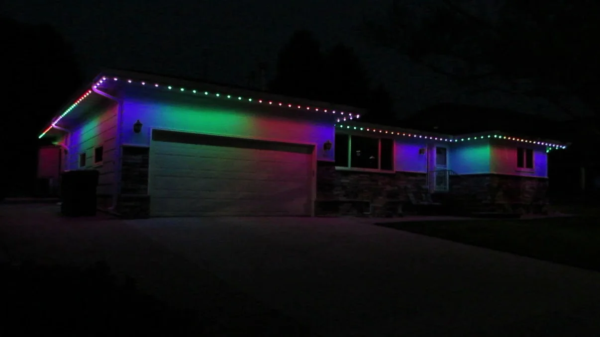 RGB LED lighting on residential home facade with color-changing strips along roofline and walls